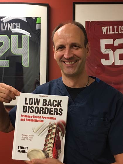 Dr. Kai Tiltmann holding Low Back Disorders by Stuart McGill